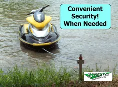 A personal watercraft secured to a dock with a cable in a calm body of water, highlighting convenient security solutions for water vehicles.