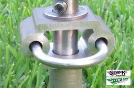 Close-up of a metallic connector piece on a stake, designed for anchoring. Relevant for discussions on secure installation of outdoor equipment.